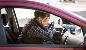 portrait of shocked male driver closing face with hands