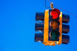 A red traffic signal with a sky blue background | Red Lights and Car Accidents