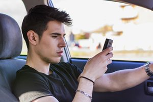 Inattentive Handsome Young Man Busy with his Mobile Phone While Driving a Car | Distracted Drivers are More Dangerous Than You Think