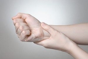woman rubbing an aching wrist | Car Accident Related Arthritis