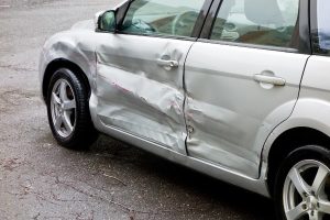 silver compact car with scraped side after an accident | Who Pays After a Colorado Springs Hit and Run Accident